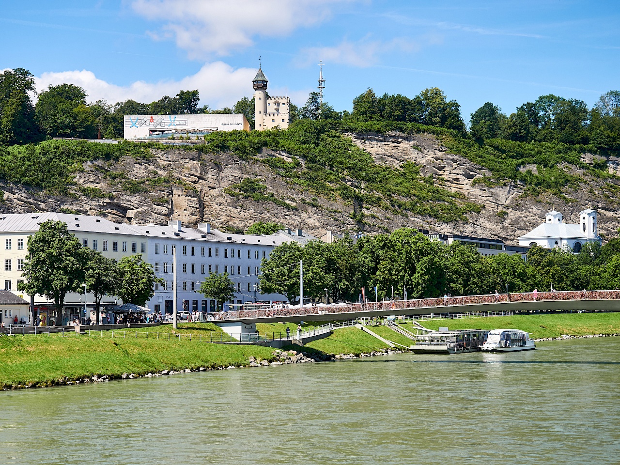 Blick auf die Salzach mit Boot und den Mönchsberg im Hintergrund